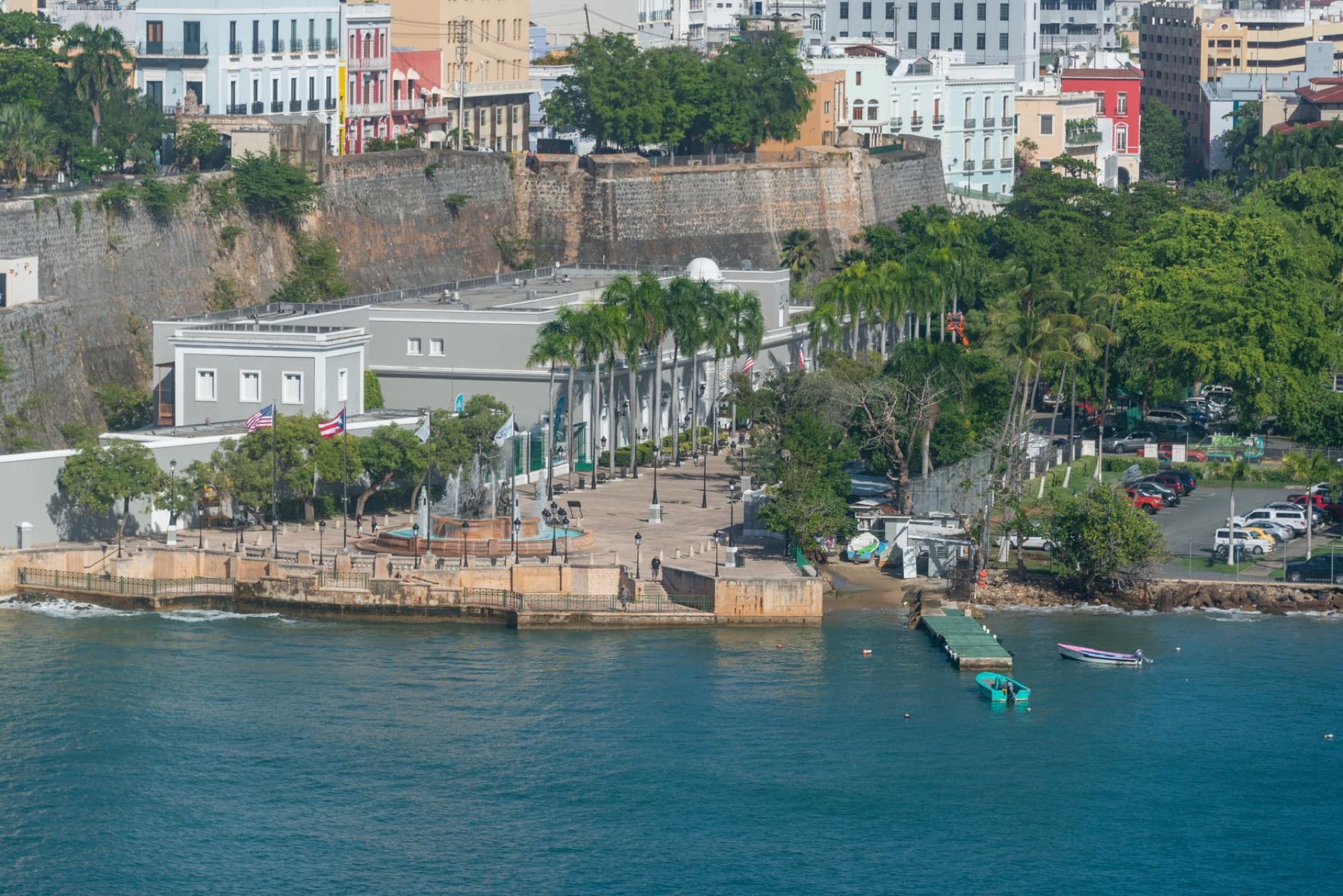 Aerial view of a coastal town with historic buildings and vibrant greenery along the shore.