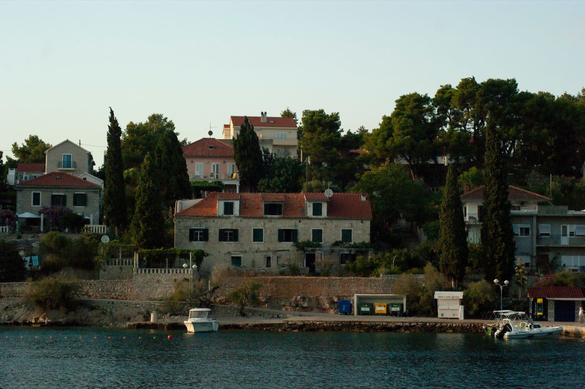 Scenic view of a quaint waterfront town with boats moored along the river.