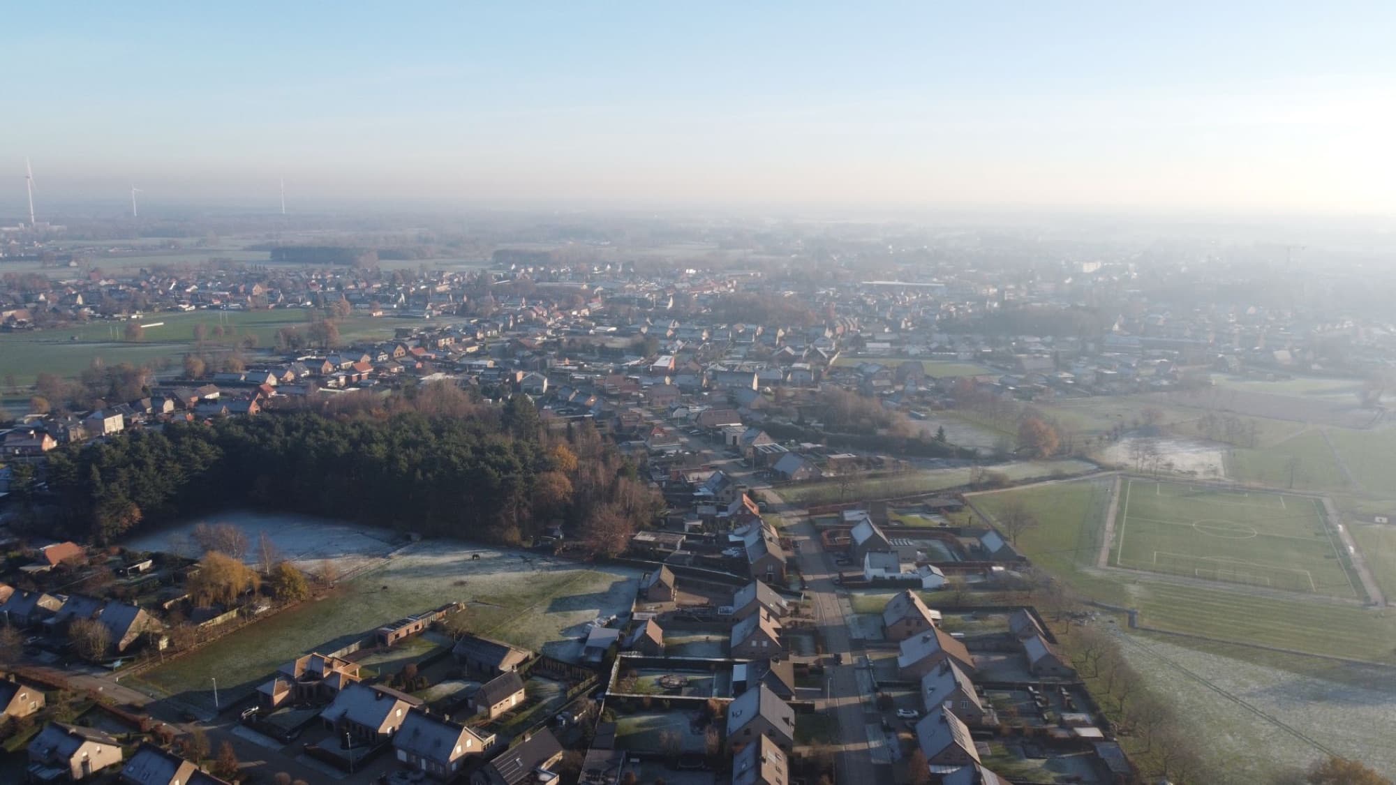 Scenic aerial image of Arendonk village in Belgium during winter, showcasing rooftops and countryside.