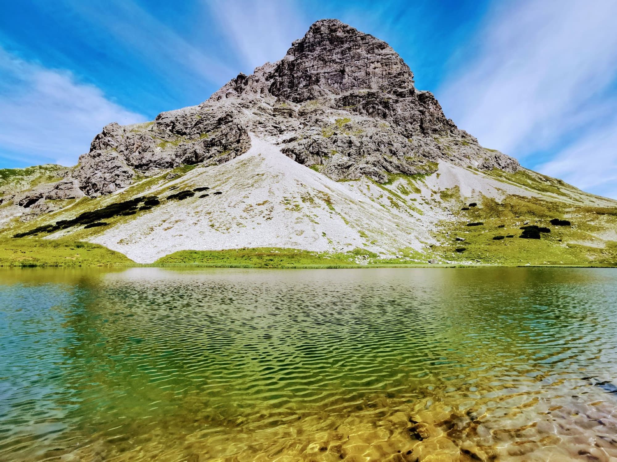 Stunning view of a mountain and lake in Vorarlberg, Austria on a clear summer day.