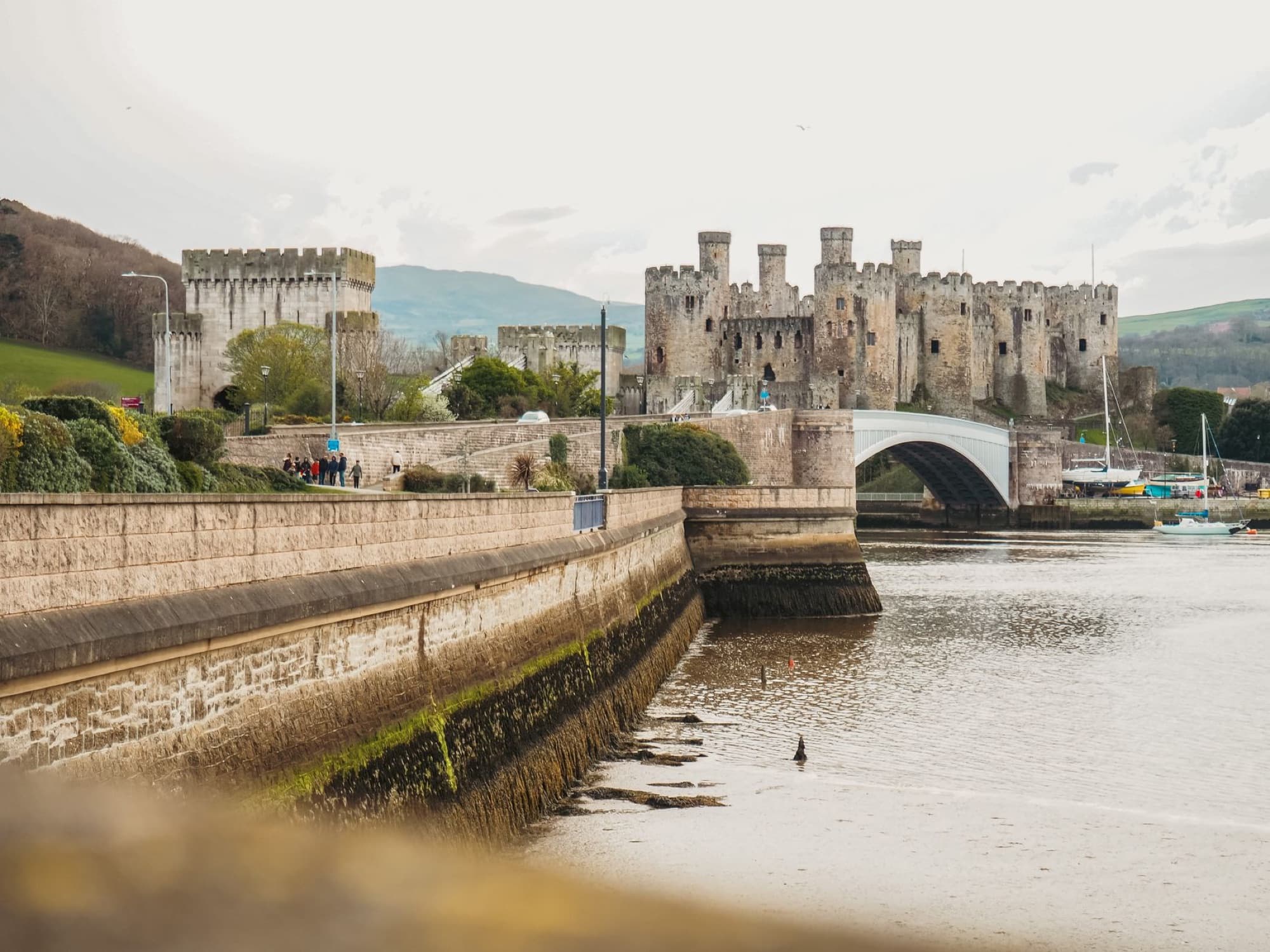 Picturesque view of Conwy Castle in Wales with river and landscape.