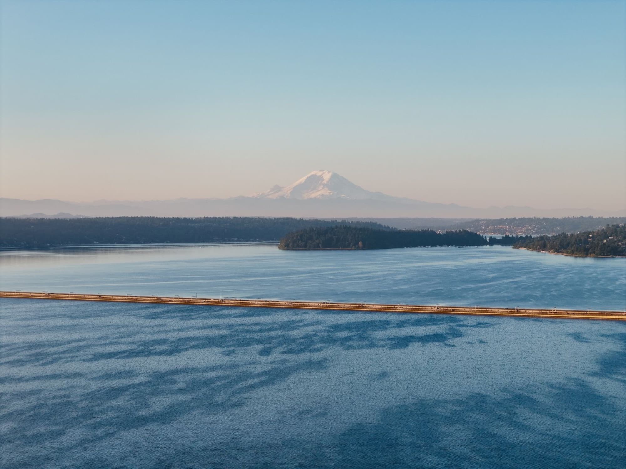 A serene landscape of Lake Washington and Mount Rainier at sunset from Seattle, WA.