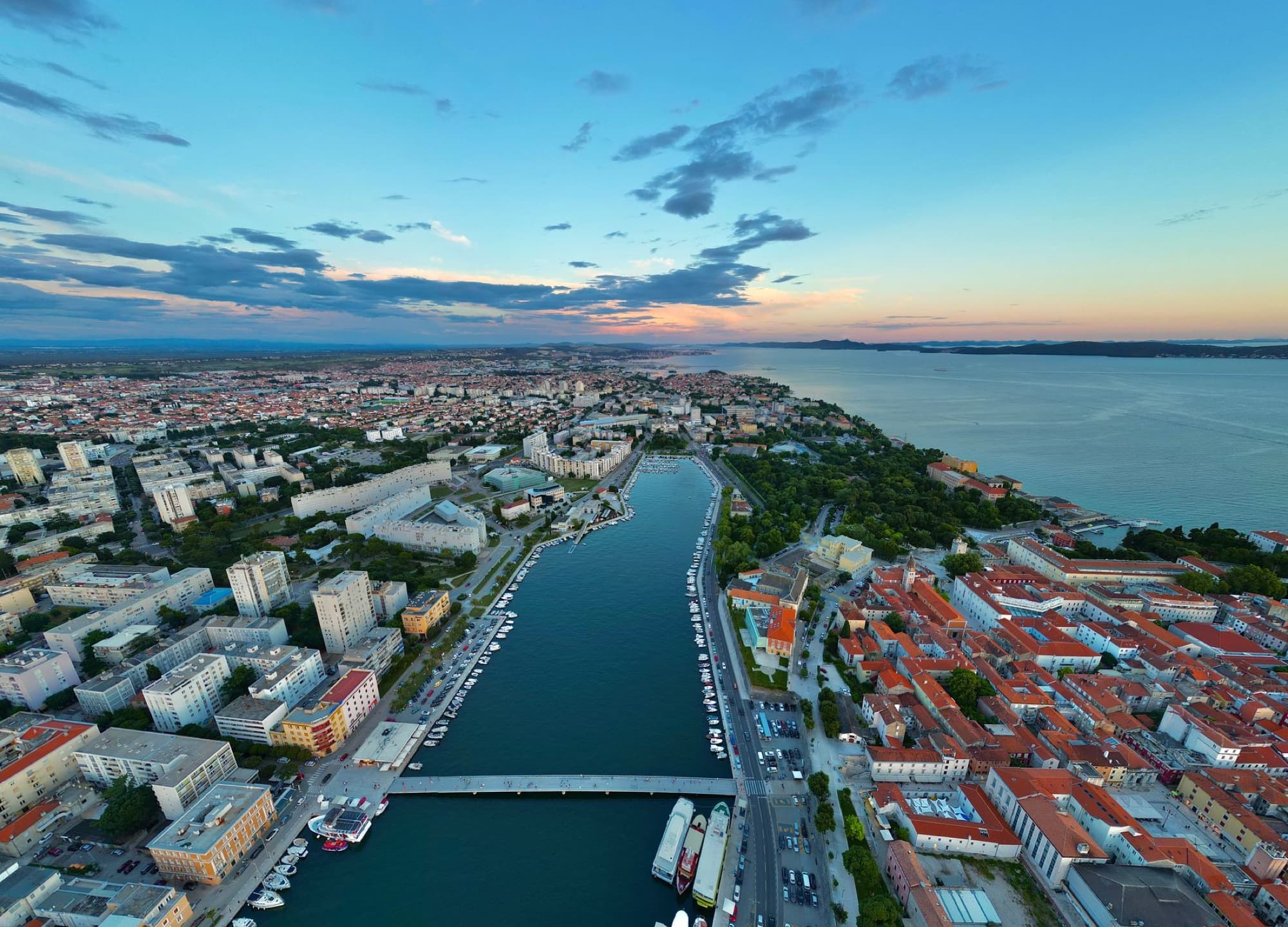 A breathtaking aerial shot of Zadar, Croatia, capturing the city's coastal beauty and vibrant skyline at sunset.