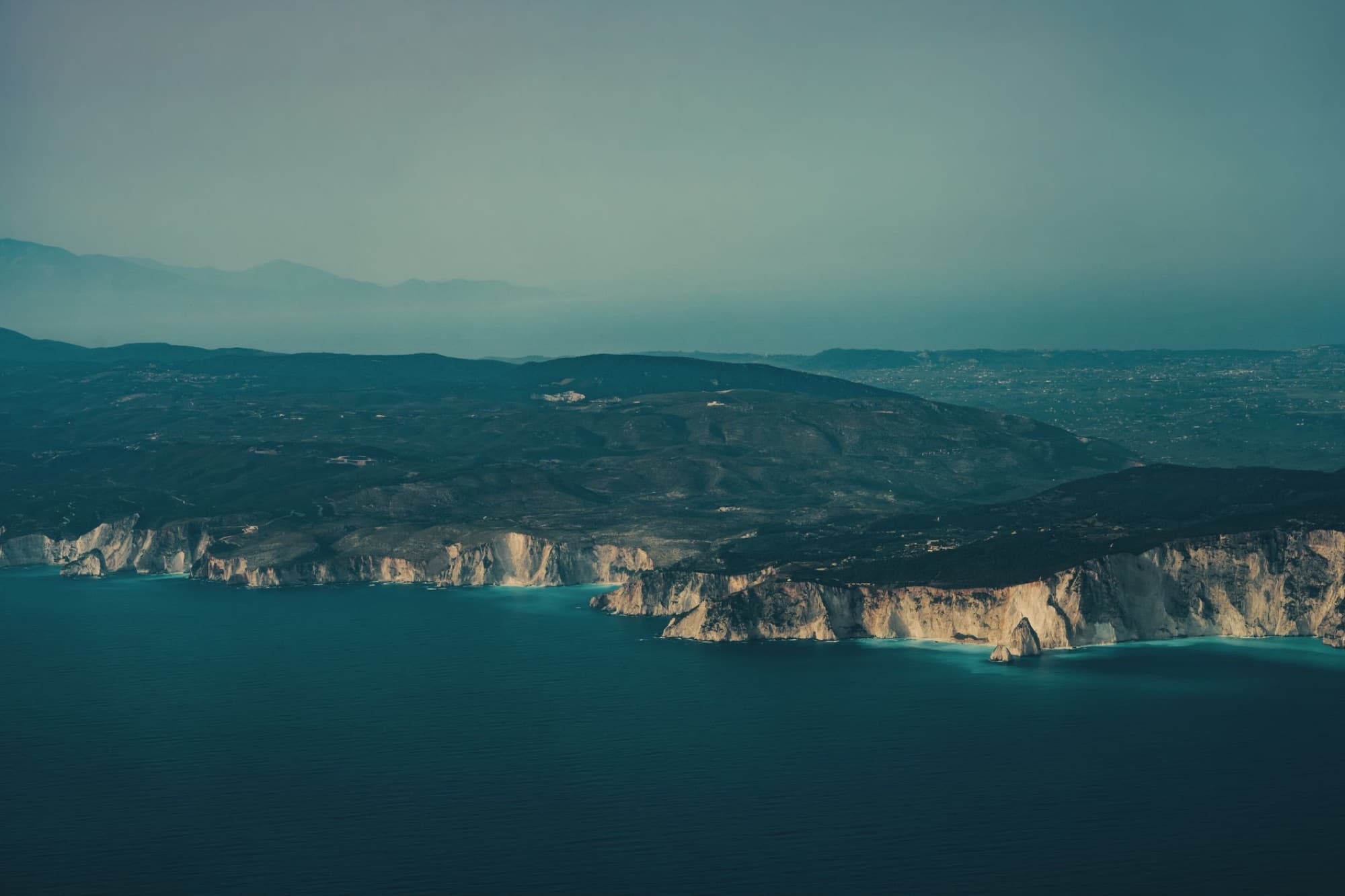 Stunning aerial shot of Zakynthos coastline, featuring dramatic cliffs and deep blue sea.