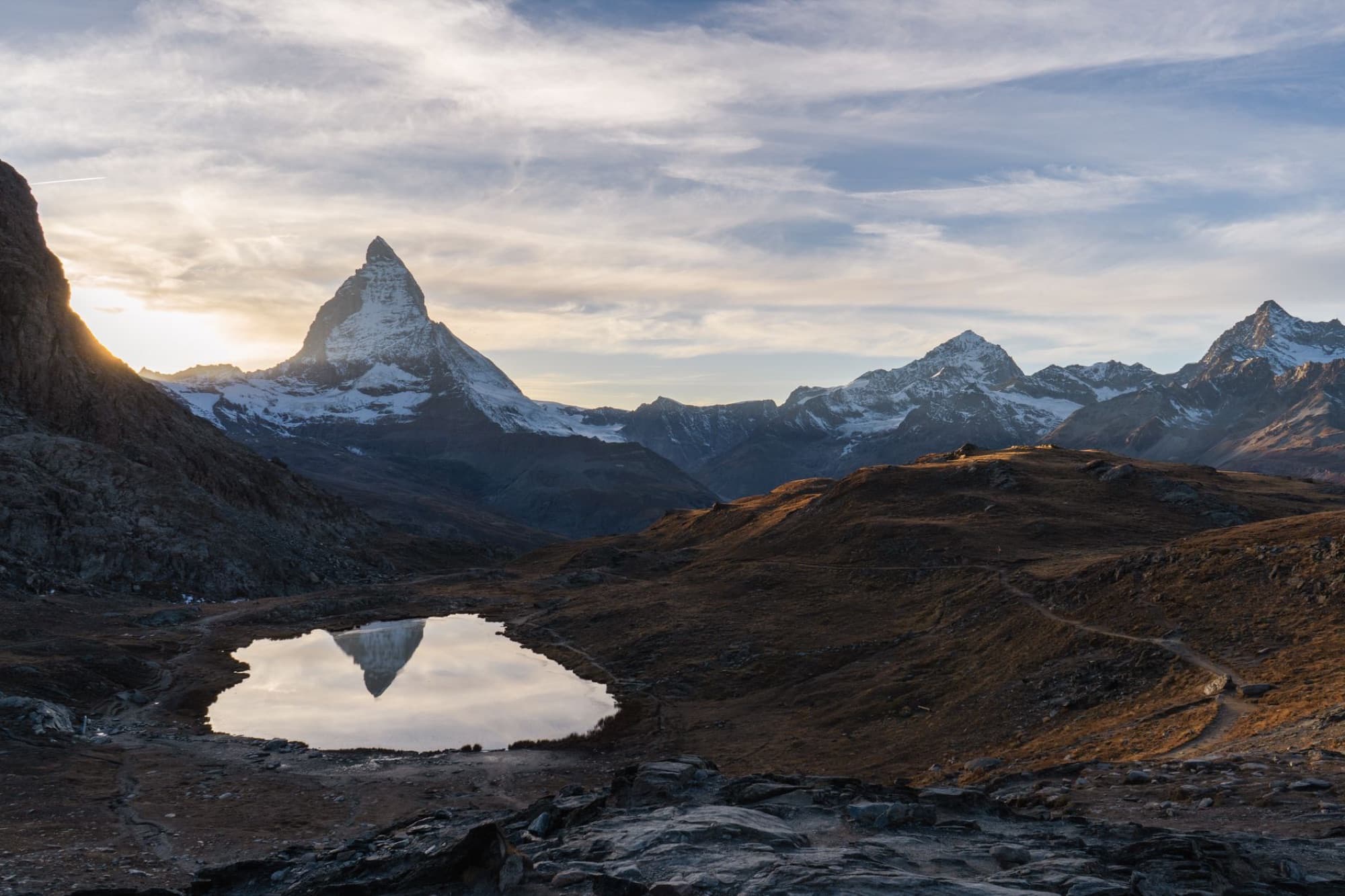 Scenic view of Matterhorn reflecting in a tranquil lake at sunrise in Zermatt, Switzerland.