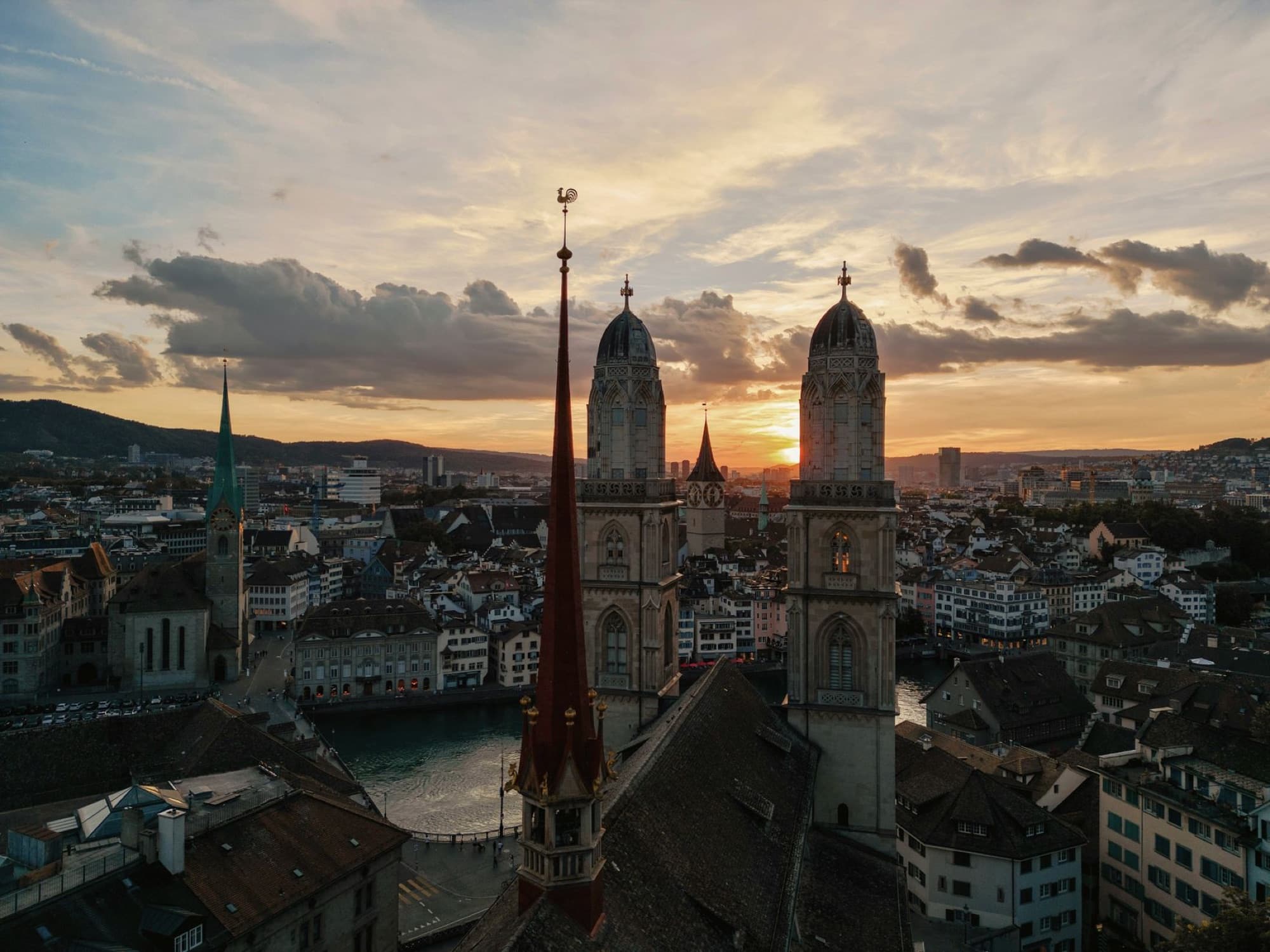 A breathtaking aerial view of Zurich with iconic landmarks during a stunning sunset.