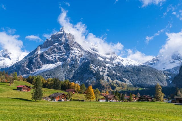 Alpine village beneath snow-capped Swiss peaks