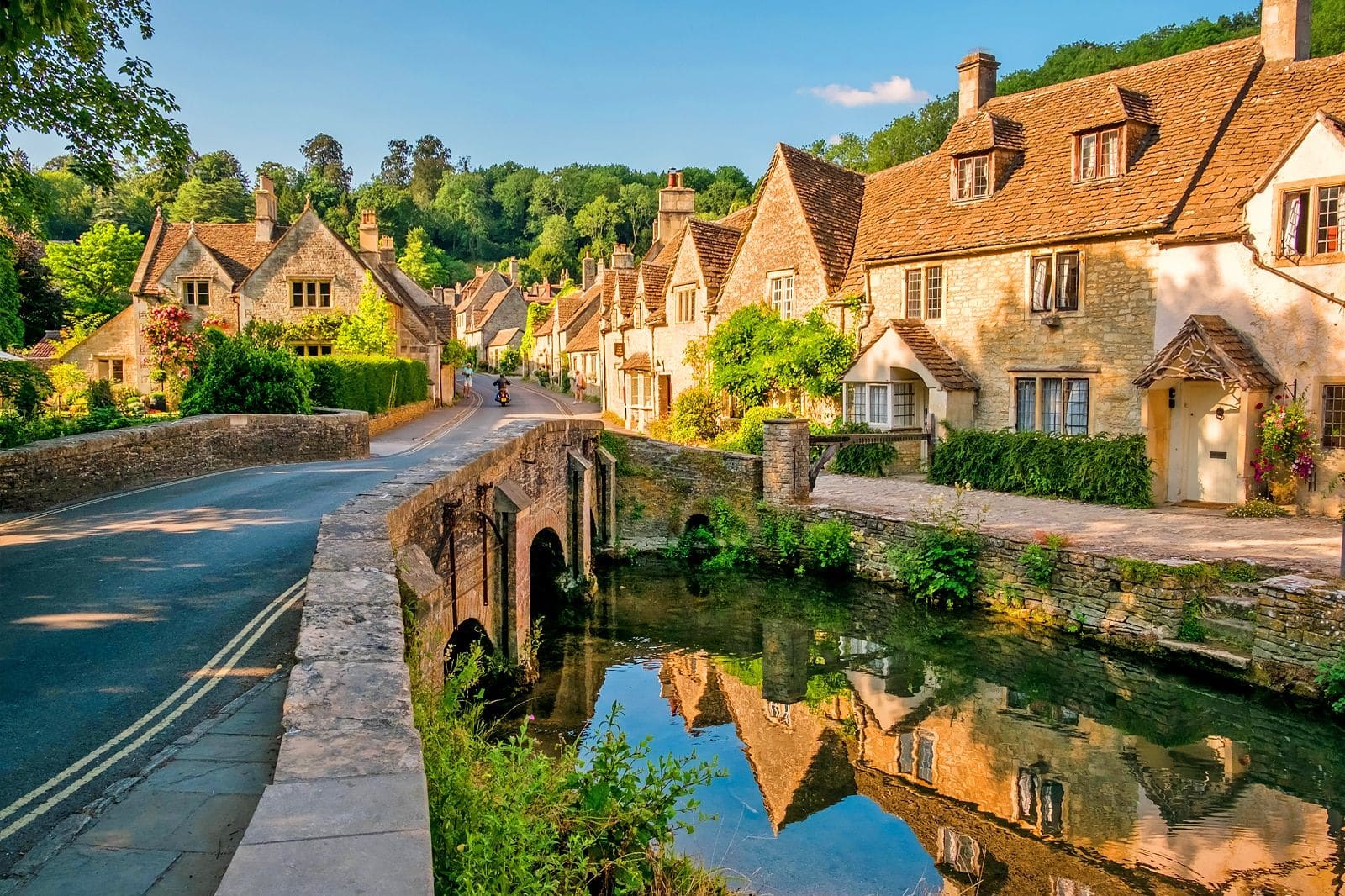 Historic stone village with a bridge over a clear stream